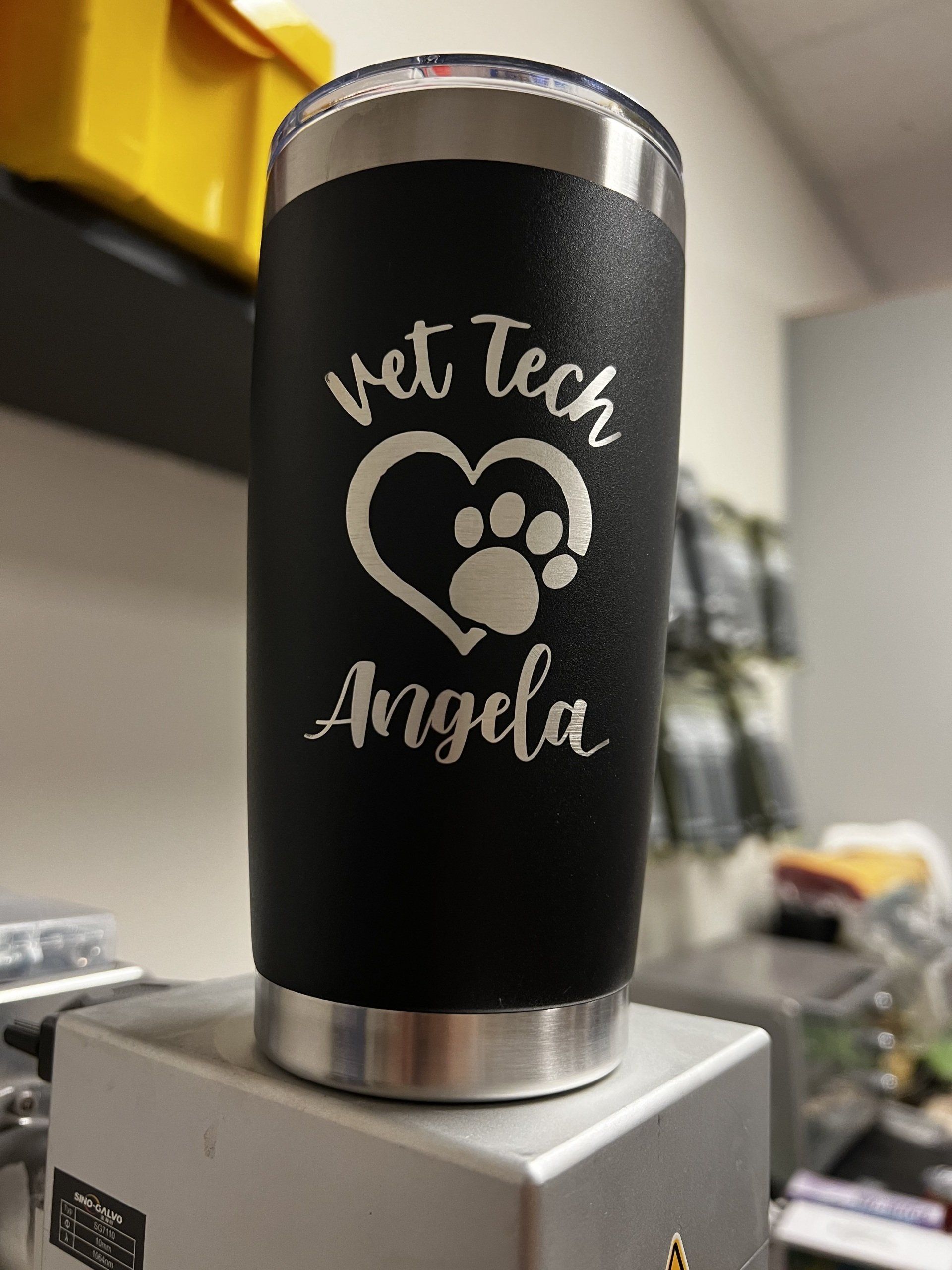 A black tumbler with the words `` vet tech angela '' on it.