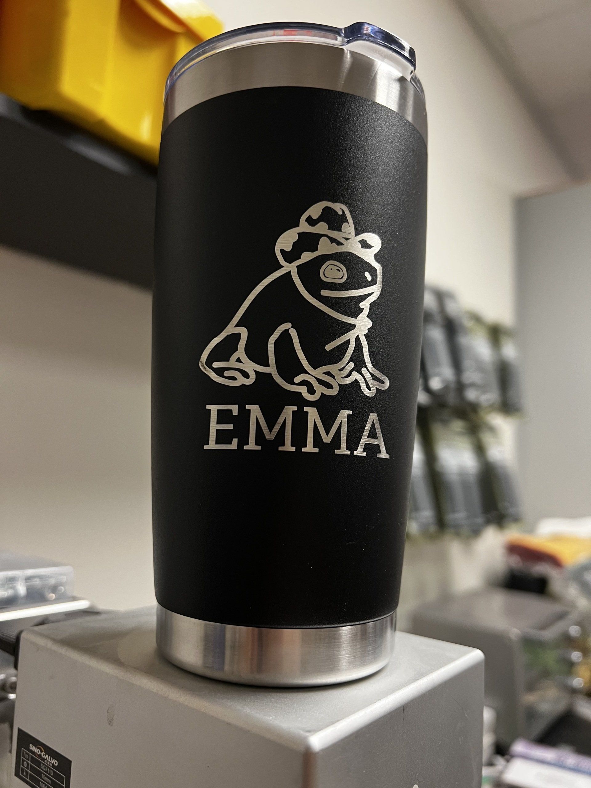 A black tumbler with a frog and the name emma on it
