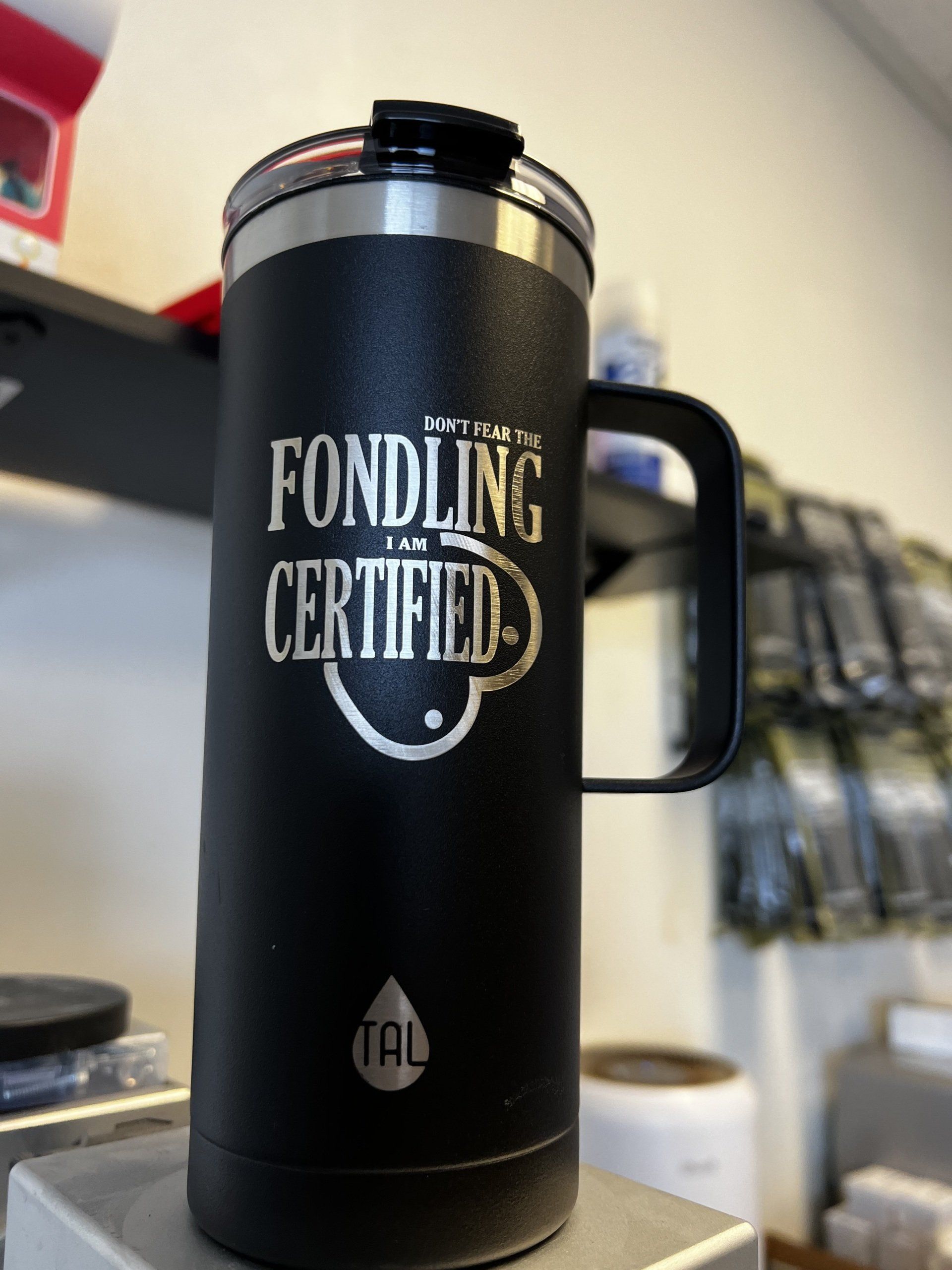 A black mug that says ' fondling certified ' on it