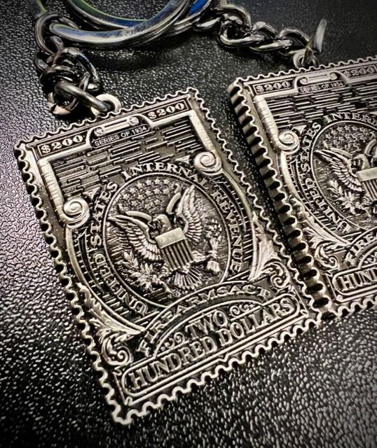 A pair of silver stamps with the words hundred dollars on them