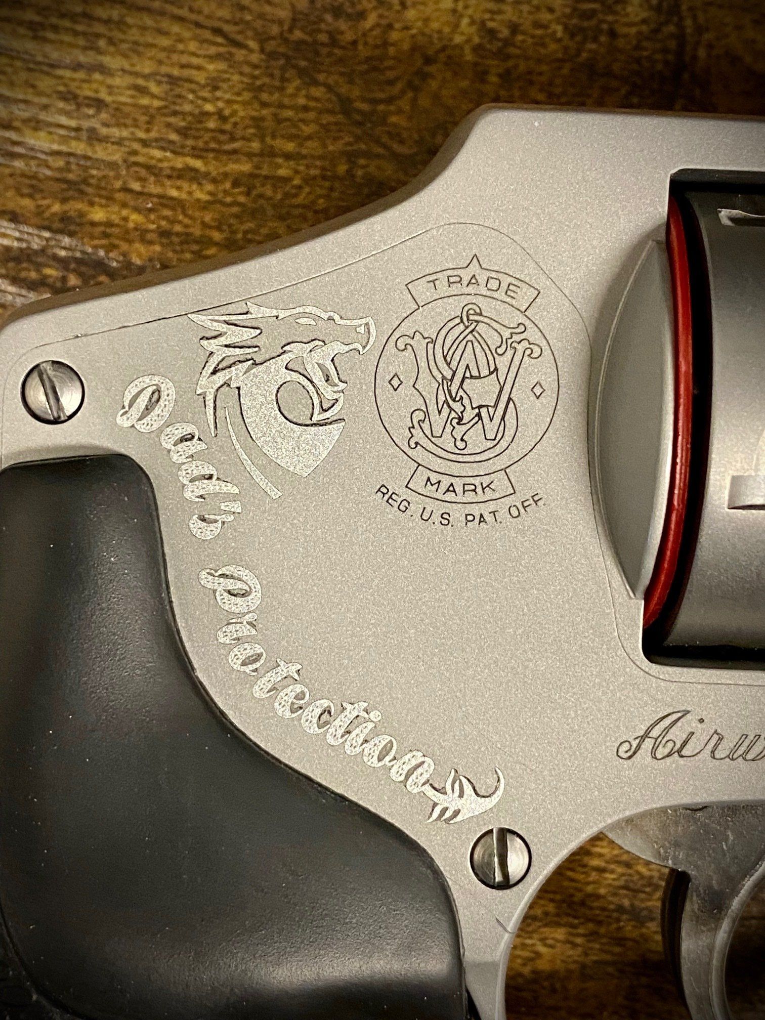 A close up of a revolver on a wooden table.