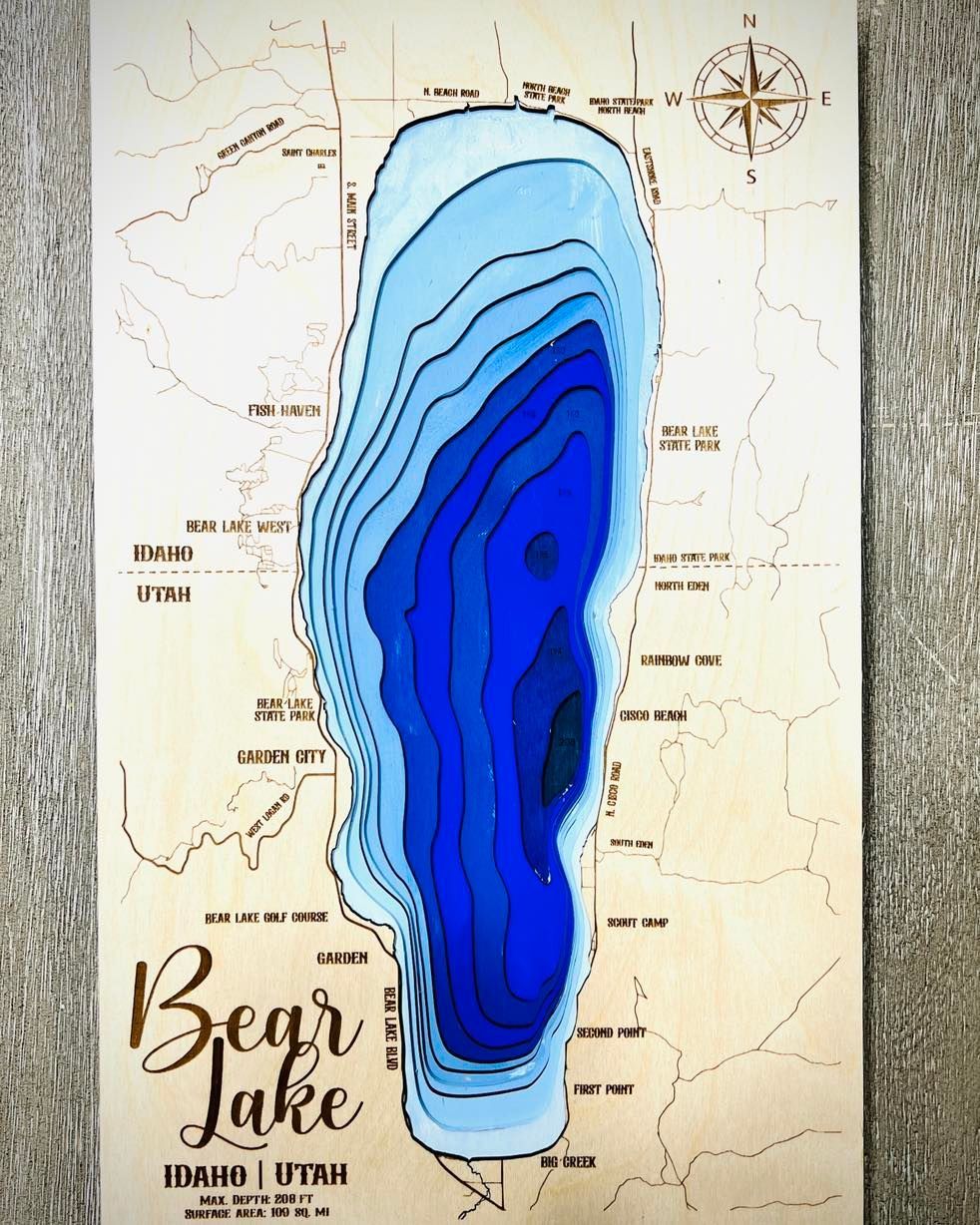 A wooden map of bear lake with a blue lake in the middle.
