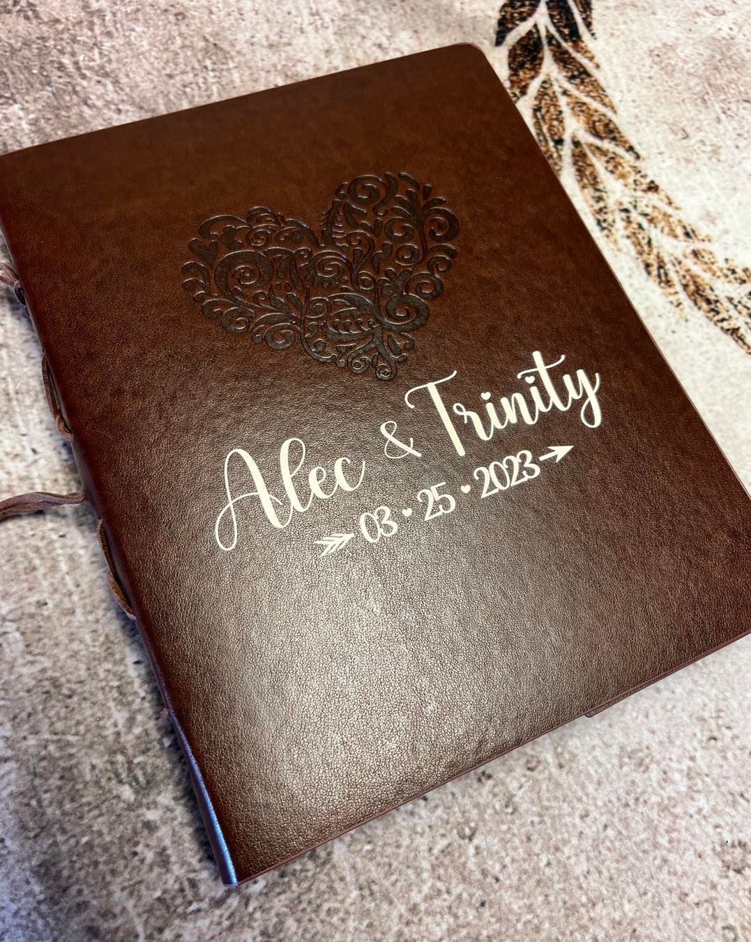 A brown book with a heart on it is sitting on a table.