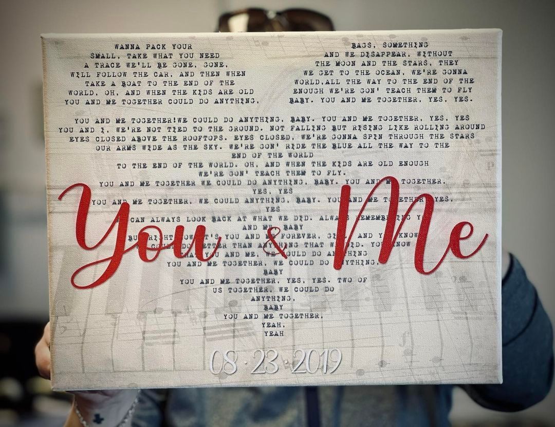 A person is holding a piece of paper that says you and me