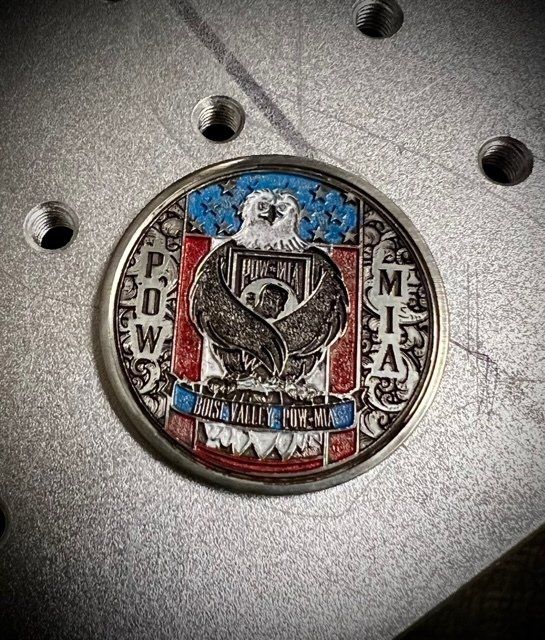 A coin with an eagle on it is on a metal surface.
