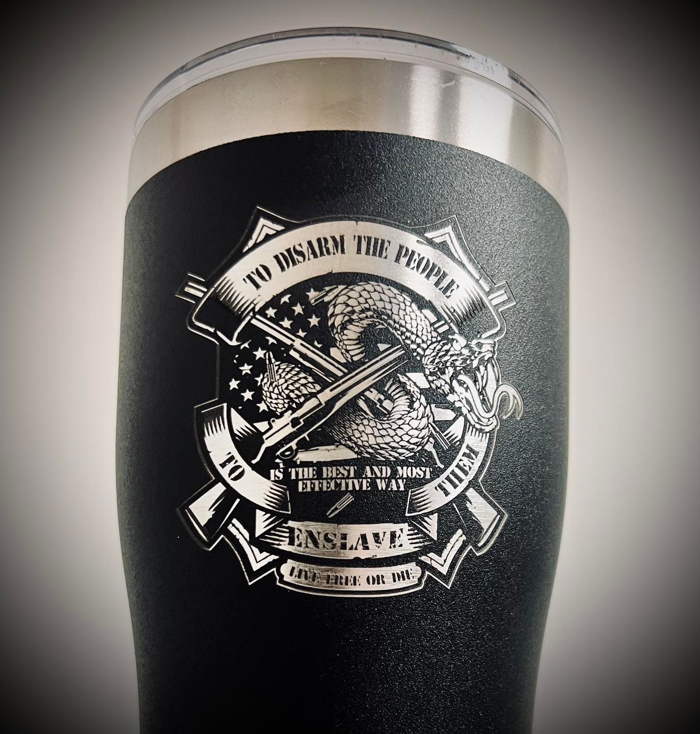 A black tumbler with the words to disarm the people engraved on it