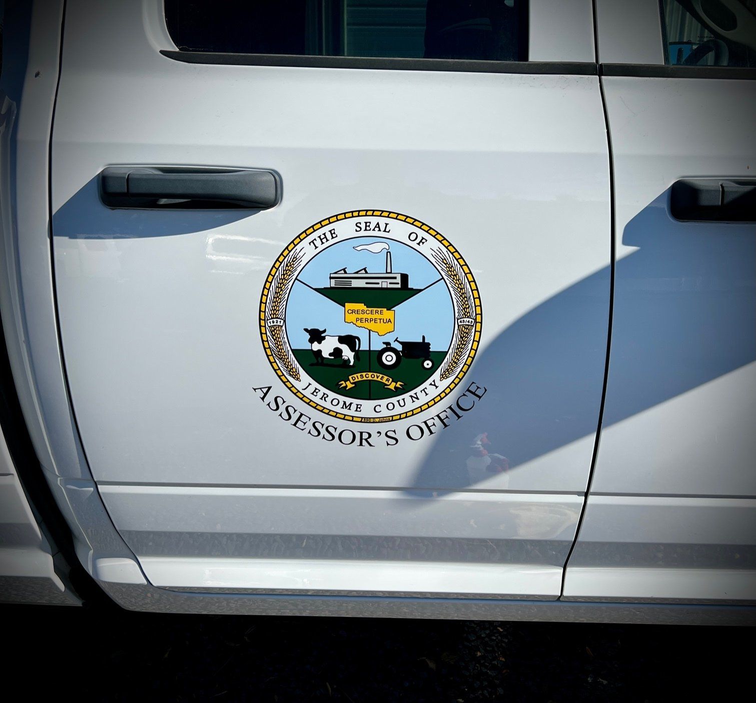 A white truck has a sticker on the side that says assessor 's office