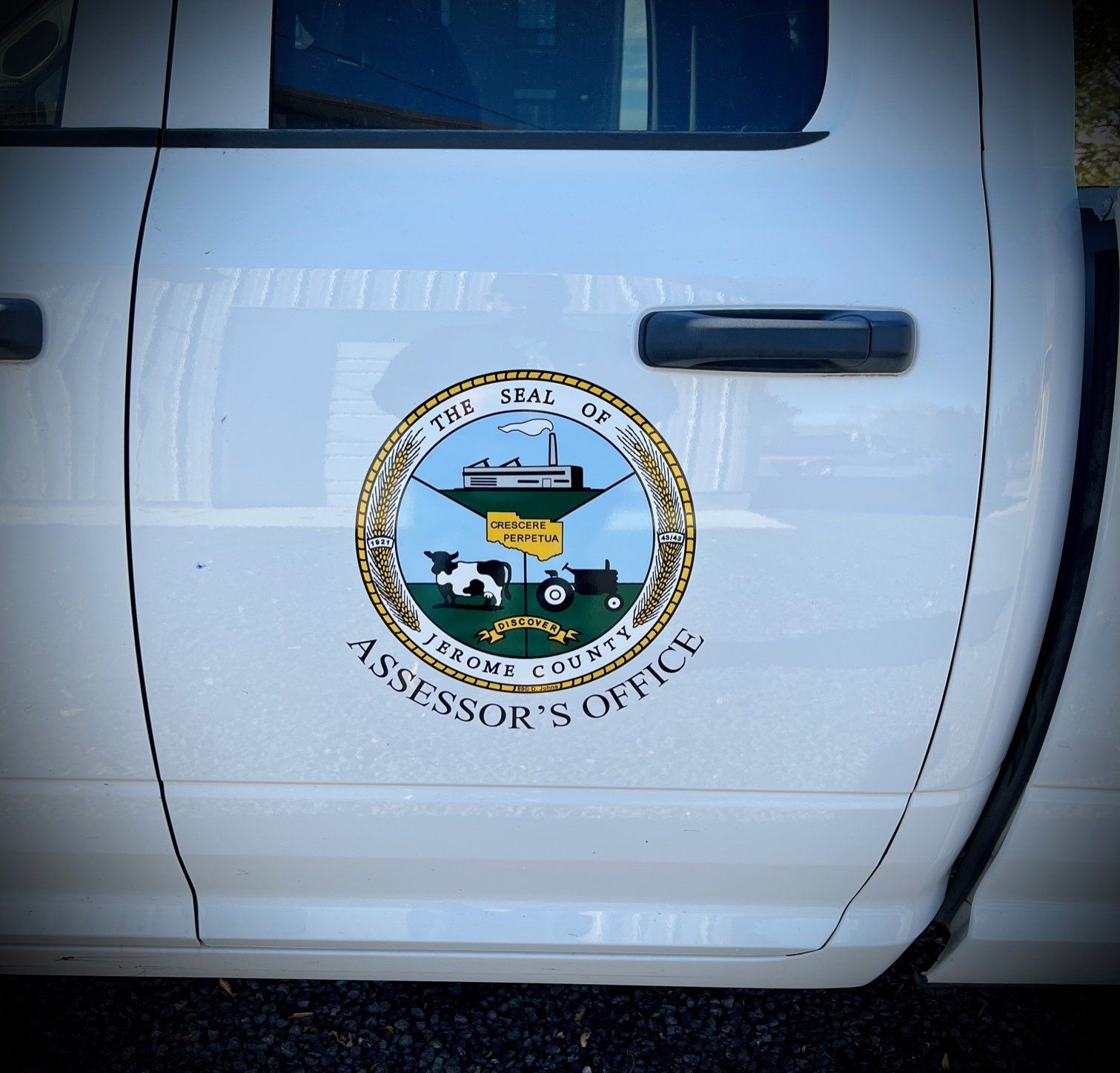 A white truck has a sticker on the side that says assessor 's office