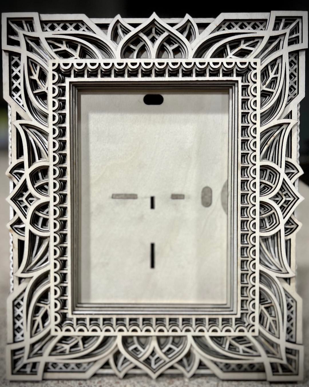 A picture frame with a floral design on it is sitting on a table.