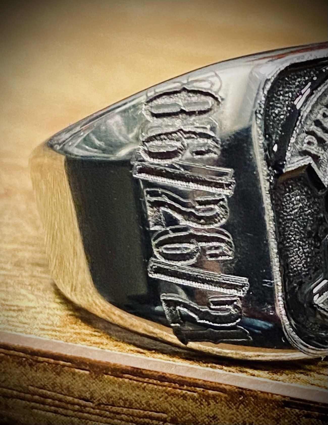 A close up of a silver ring on a wooden table.