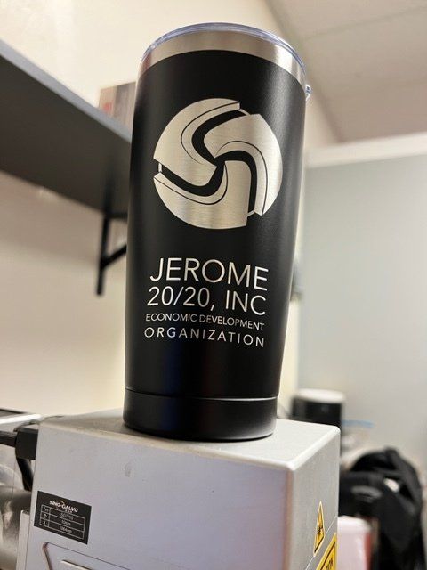 A black tumbler with the name jerome on it is sitting on top of a machine.