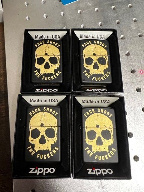 Four zippo lighter cases with skulls on them