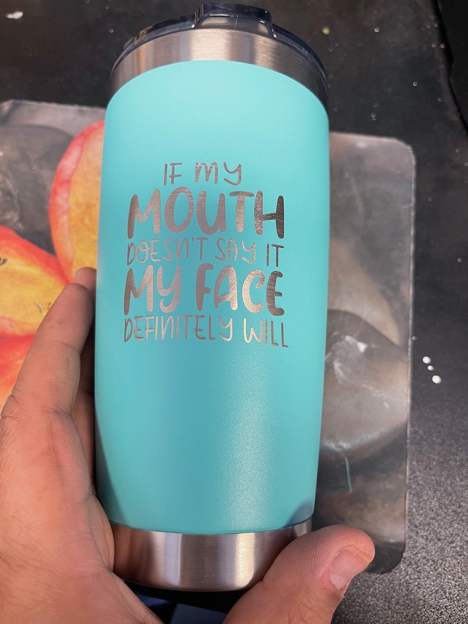 A person is holding a tumbler that says if my mouth does n't say it my face definitely will