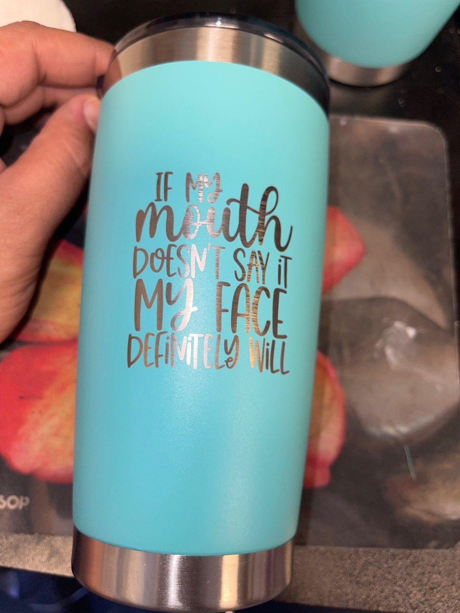 A person is holding a blue tumbler that says `` if my mouth does n't say it my face definitely will ''