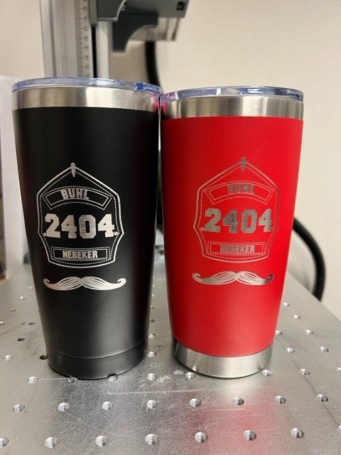 Two tumblers with mustaches on them are sitting on a table.