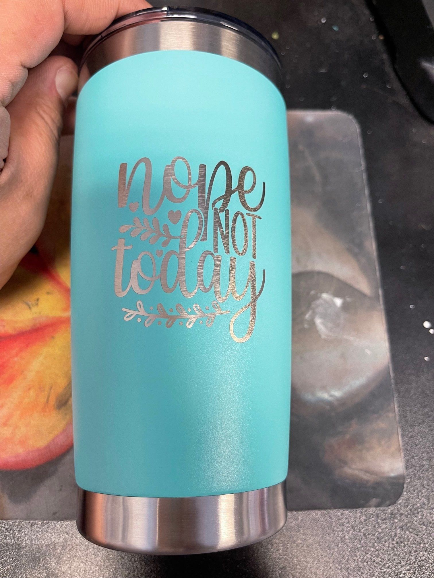 A person is holding a turquoise tumbler that says `` hope is not today ''.