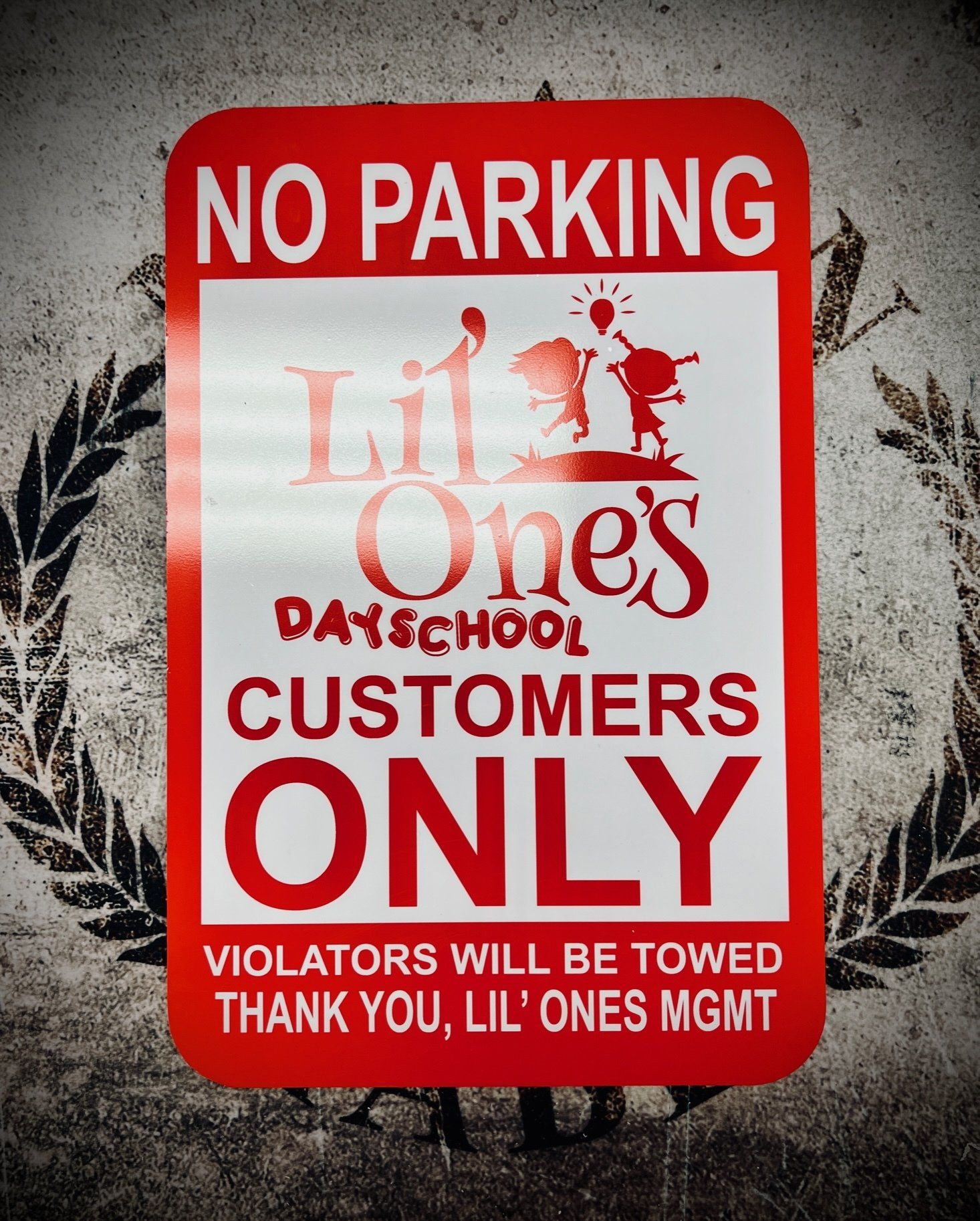 A no parking sign for lil ' ones dayschool customers only