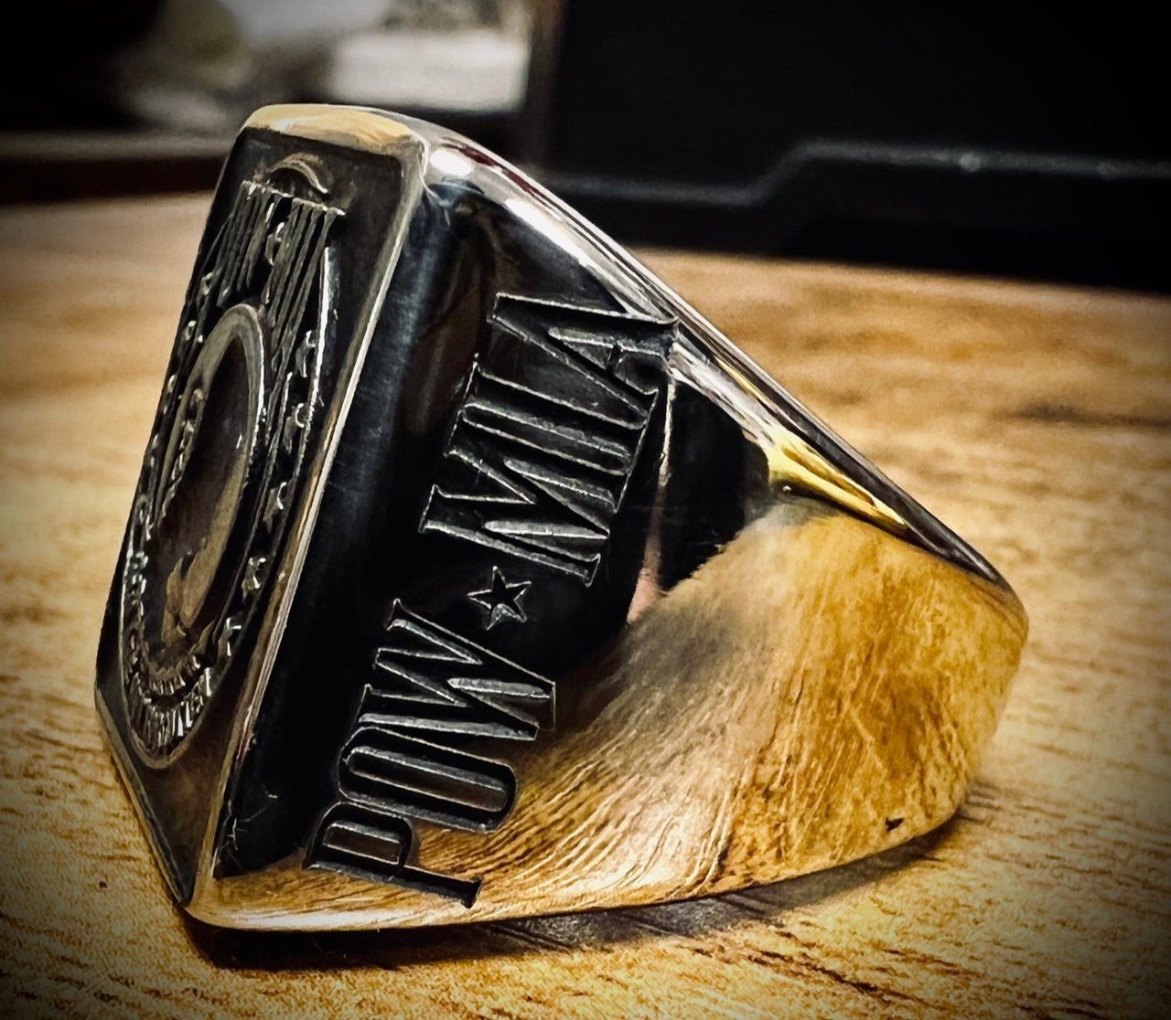 A silver ring with the word pow on it