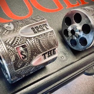A close up of a ring and a revolver on a table.