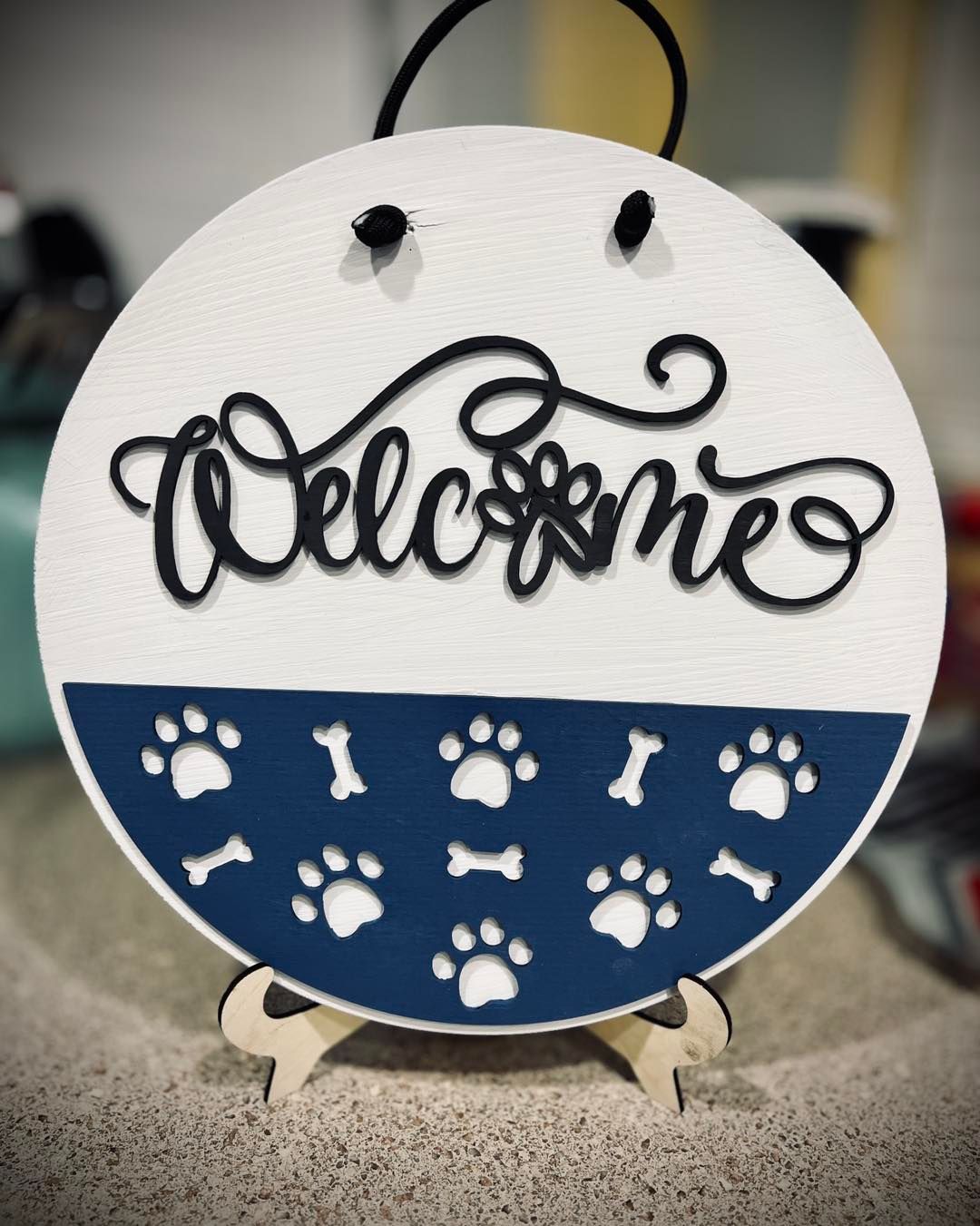 A welcome sign with paw prints and bones on it