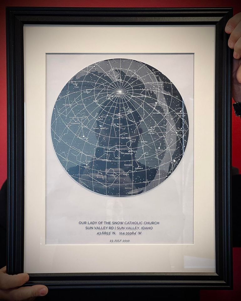 A person is holding a framed picture of the moon