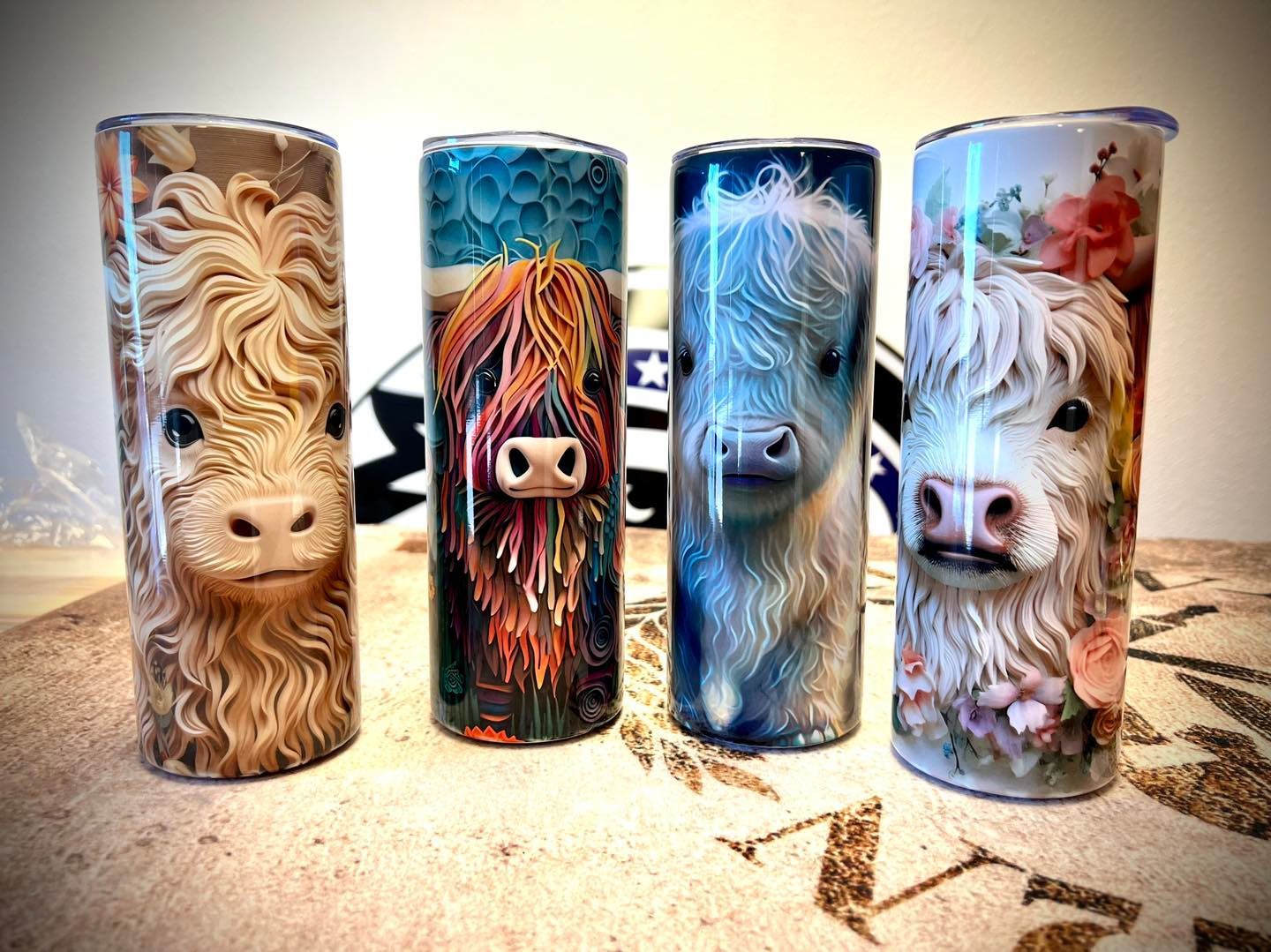 Three stainless steel tumblers with cows on them are sitting on a table.