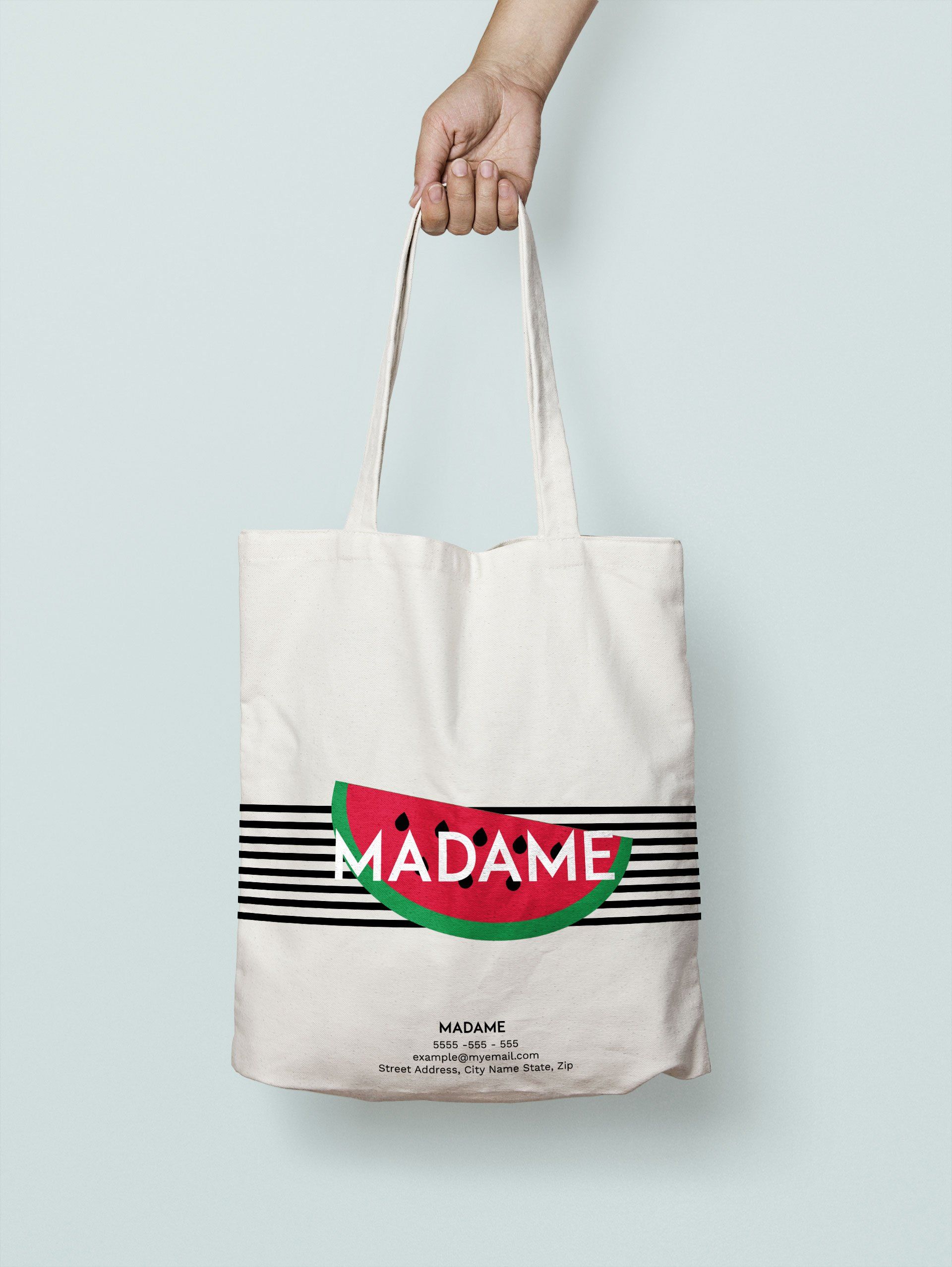 A person is holding a tote bag with a watermelon on it.