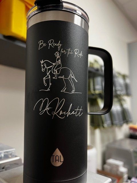 A black mug with a man riding a horse on it.