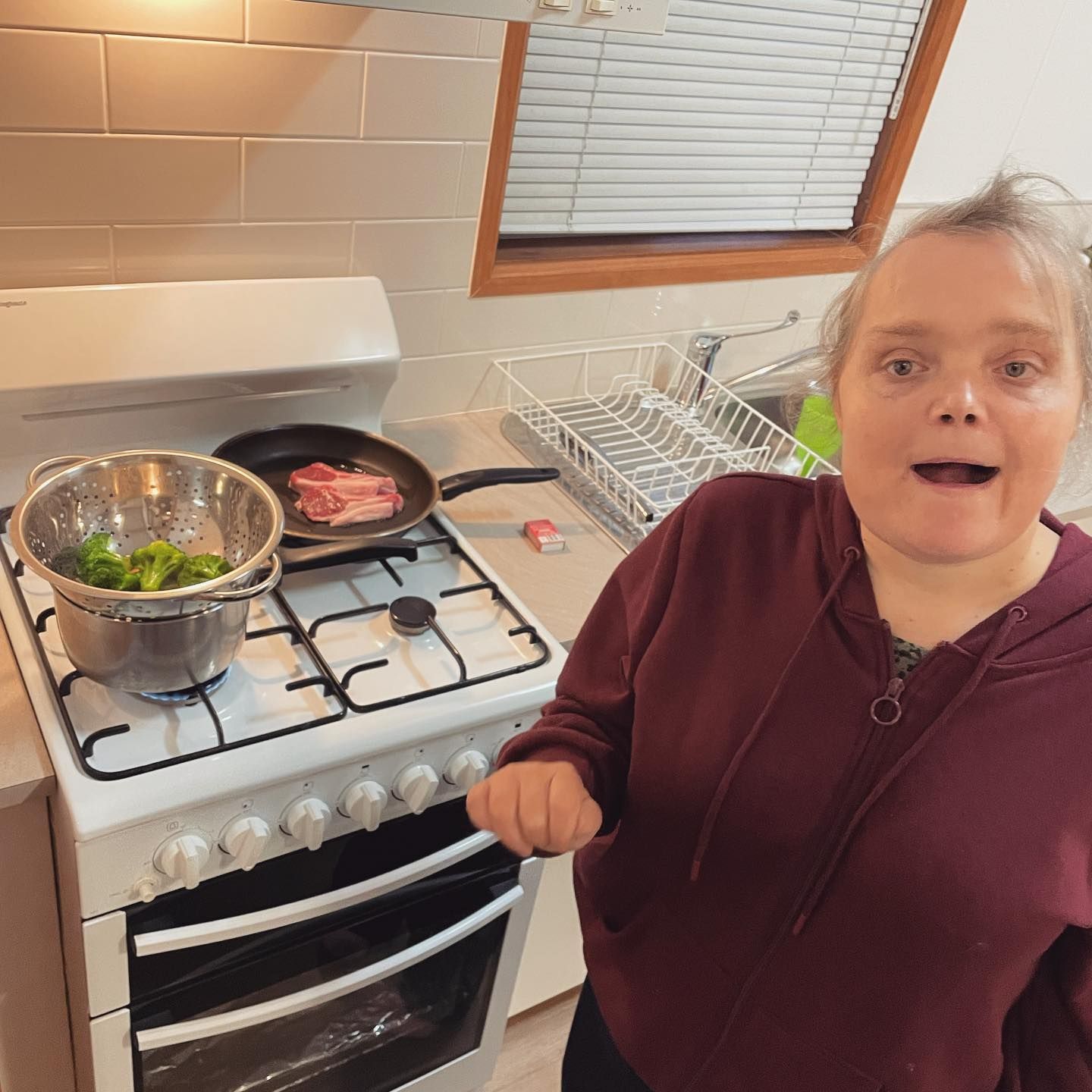 A woman and a little girl are playing with a blue exercise ball.