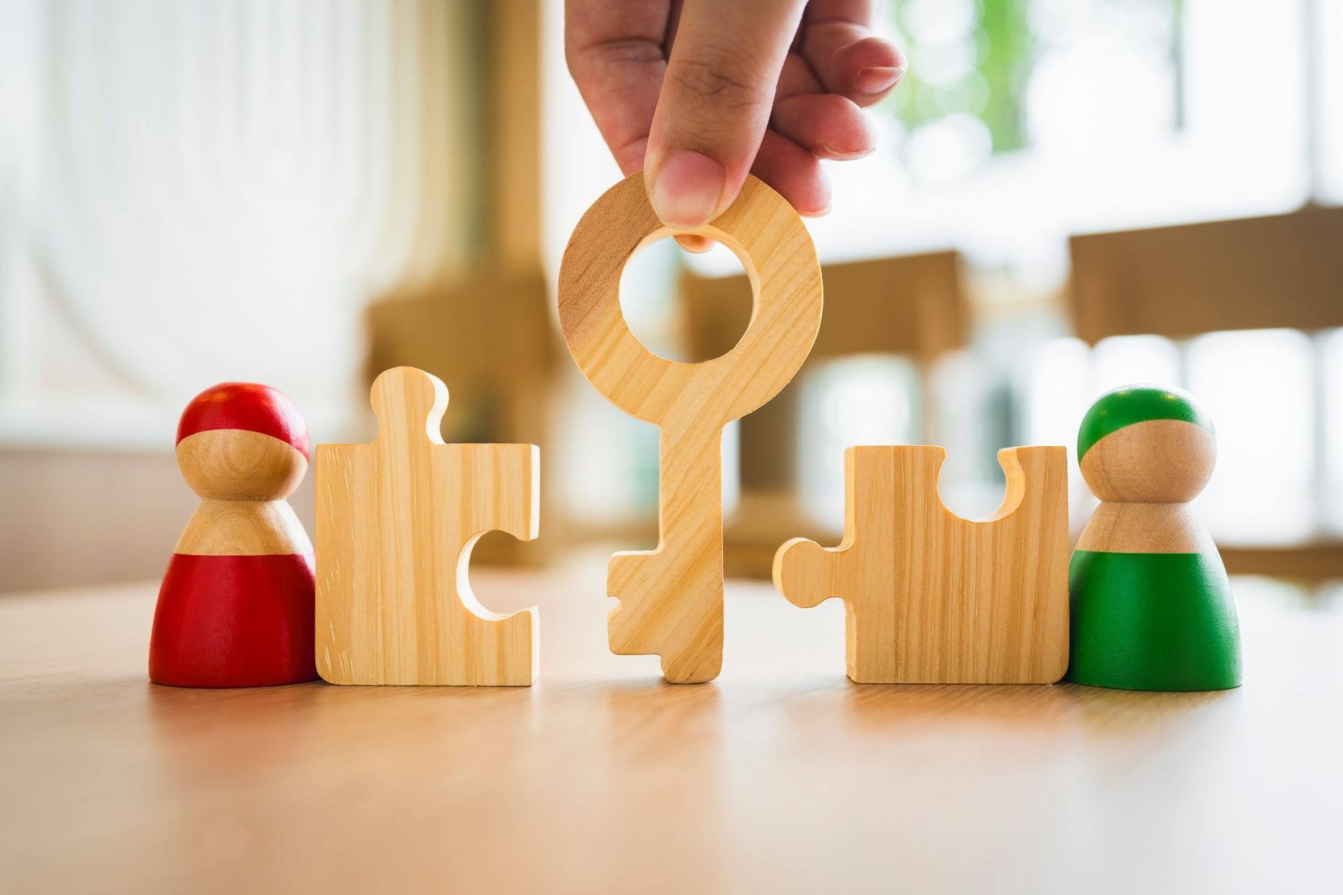A person is putting a wooden key into a wooden puzzle.