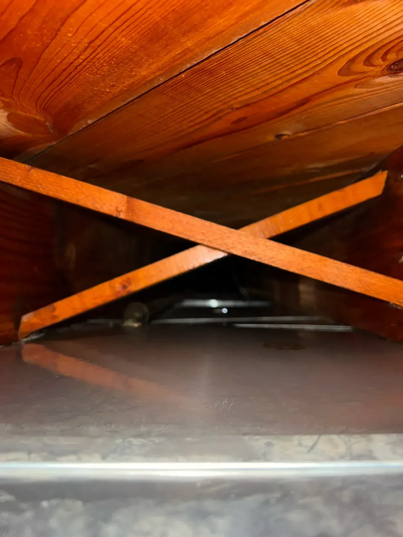 A wooden table is sitting underneath a plastic container
