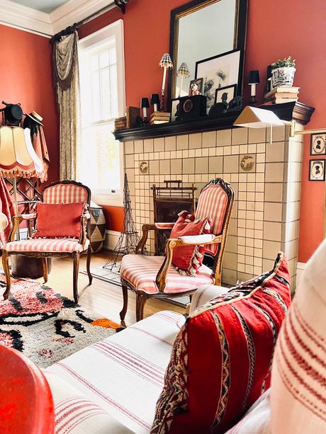 Antique vanity table with mirror, glassware, and decorations. Blue wall, sconces, and lamps.