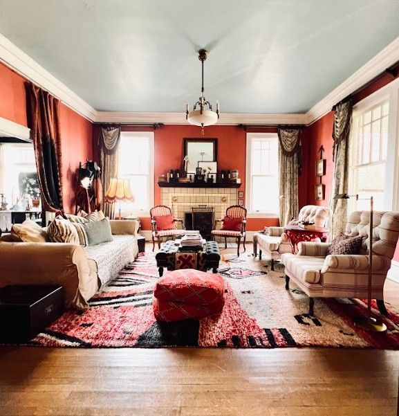 Elegant dining room with a round table set for a meal, a chandelier, and a window seat.