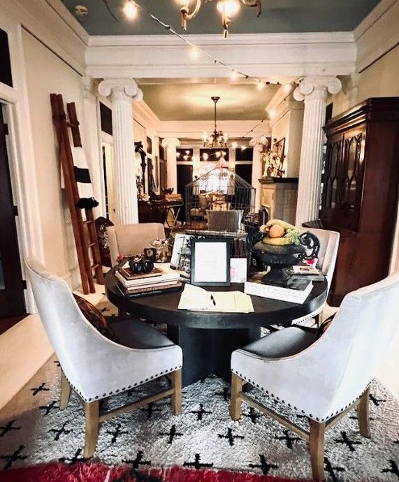 Bathroom with ornate gold mirrors, black and white wallpaper, marble countertop, and a lamp.