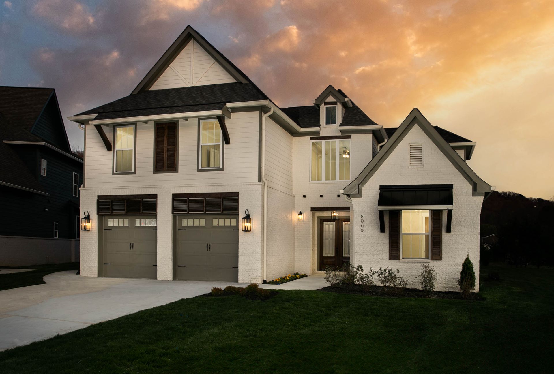 A large white house with a sunset in the background