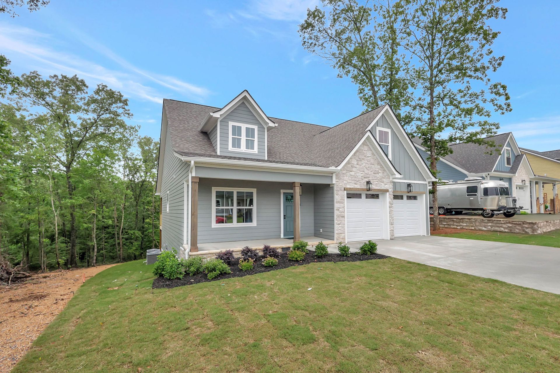A house with a rv parked in front of it.