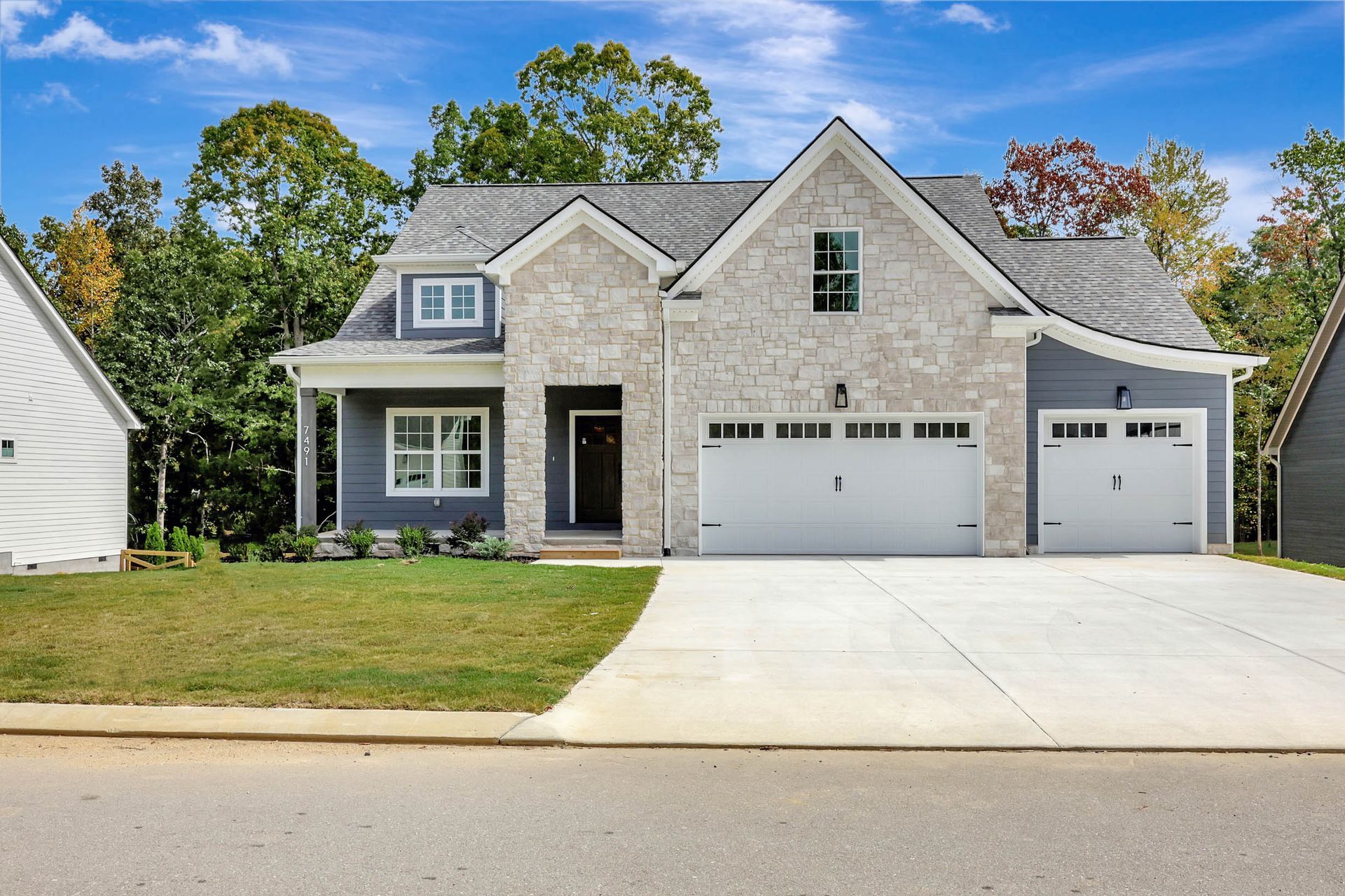 A large house with a garage and a driveway in front of it.
