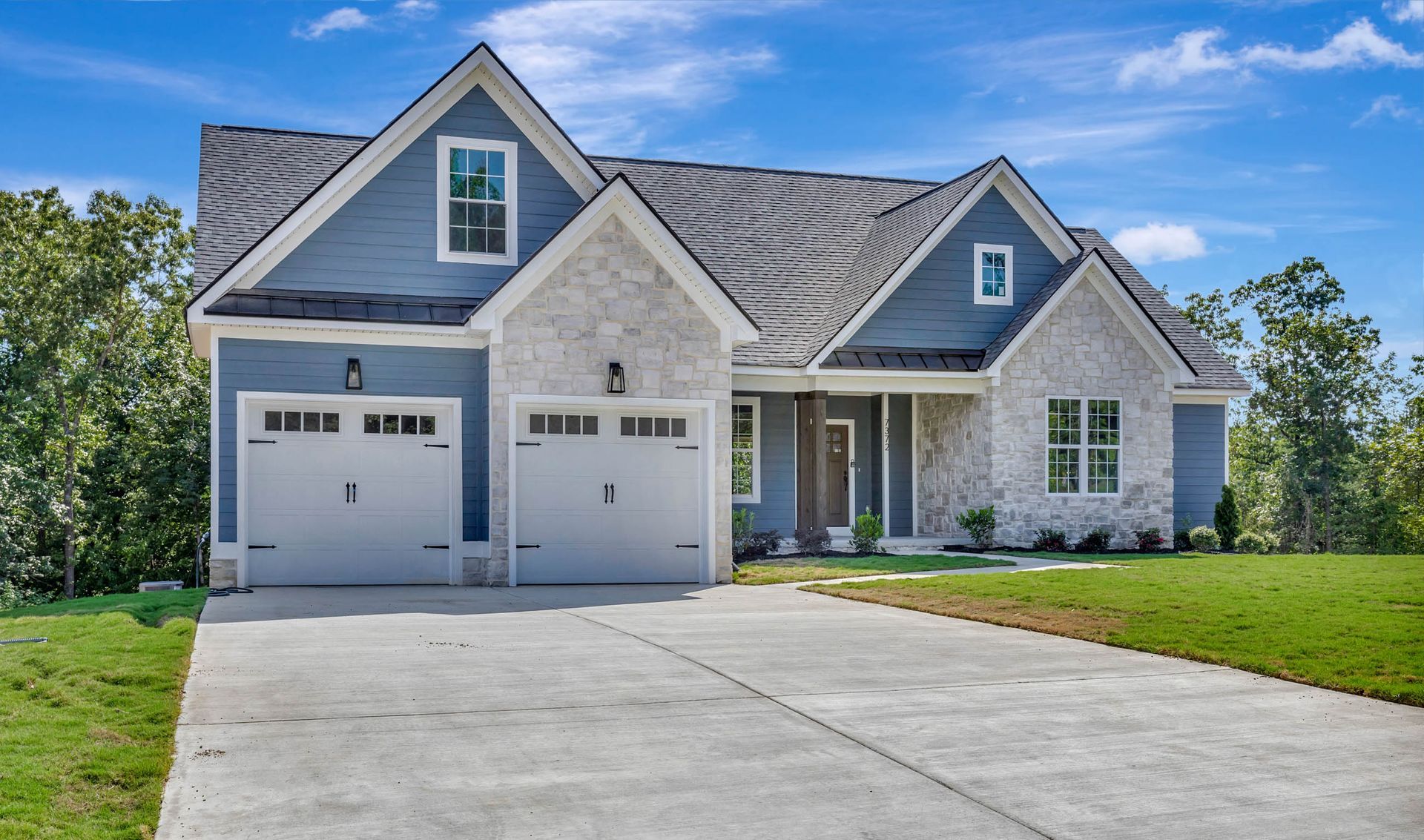 A large house with two garages and a driveway is for sale.