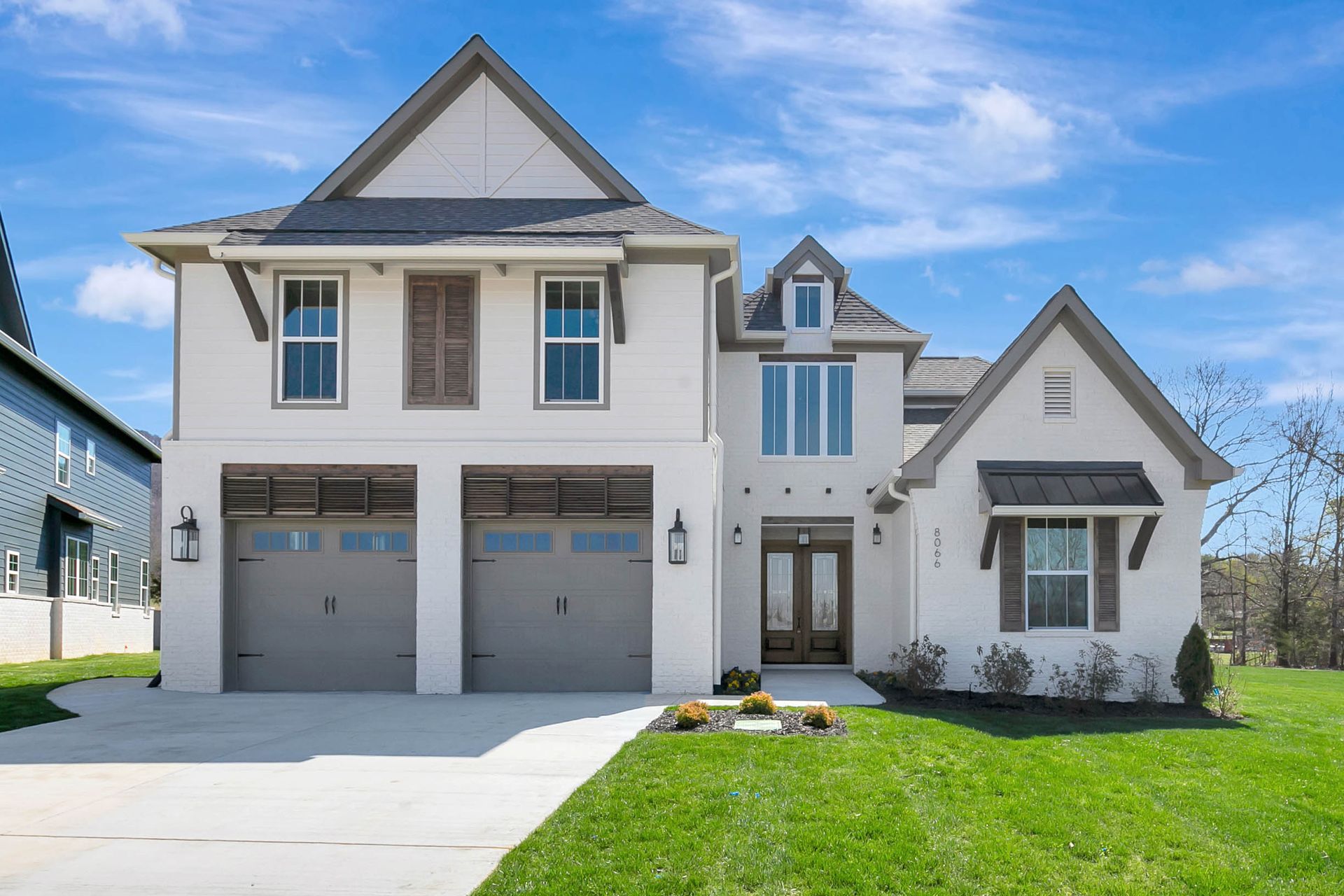 A large white house with a gray garage door