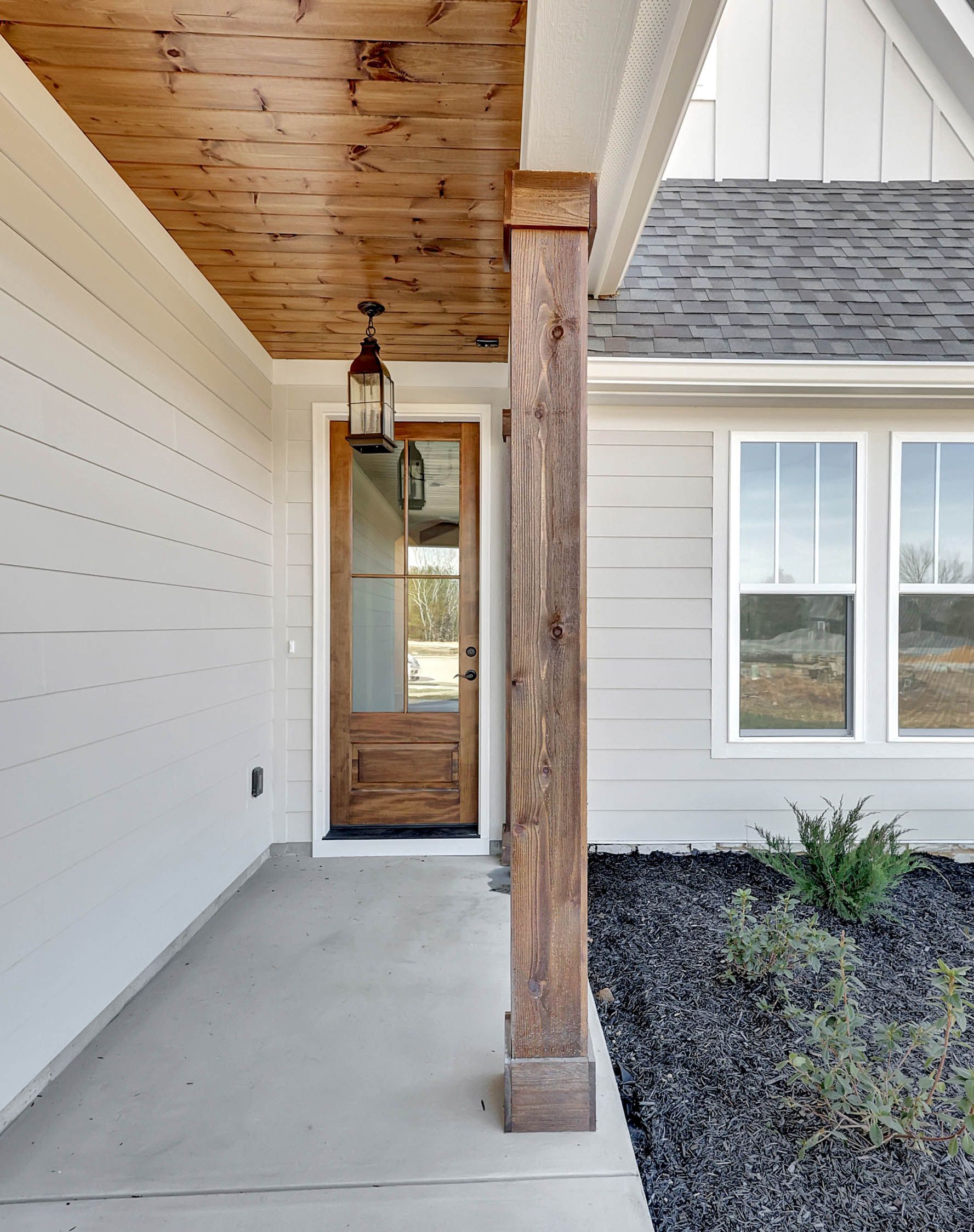 A white house with a wooden porch and a wooden door