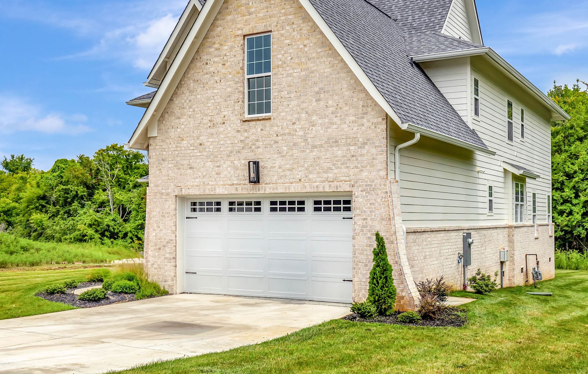 A house with a garage and a driveway in front of it.