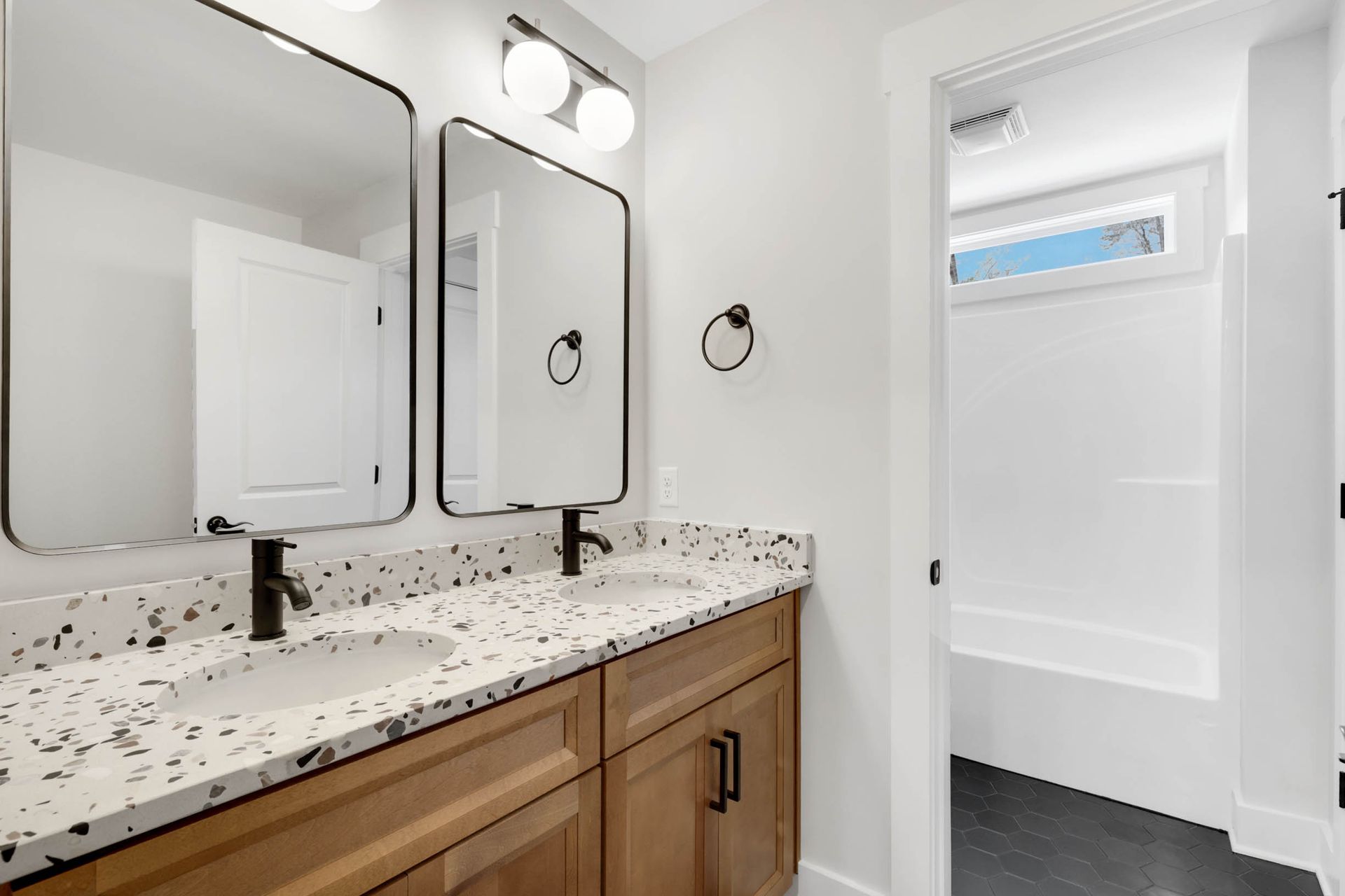 A bathroom with two sinks and two mirrors.