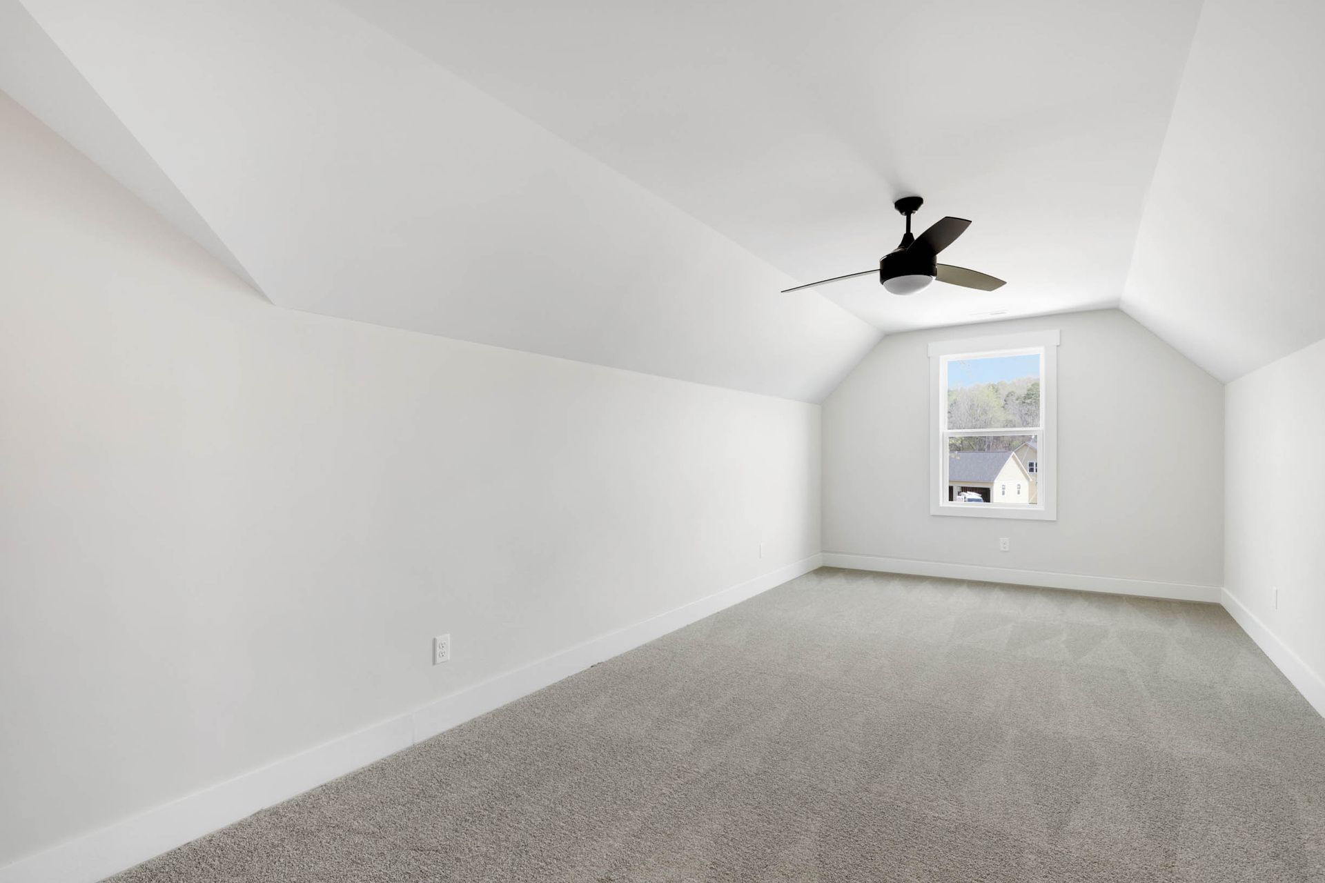 An empty bedroom with a ceiling fan and a window.