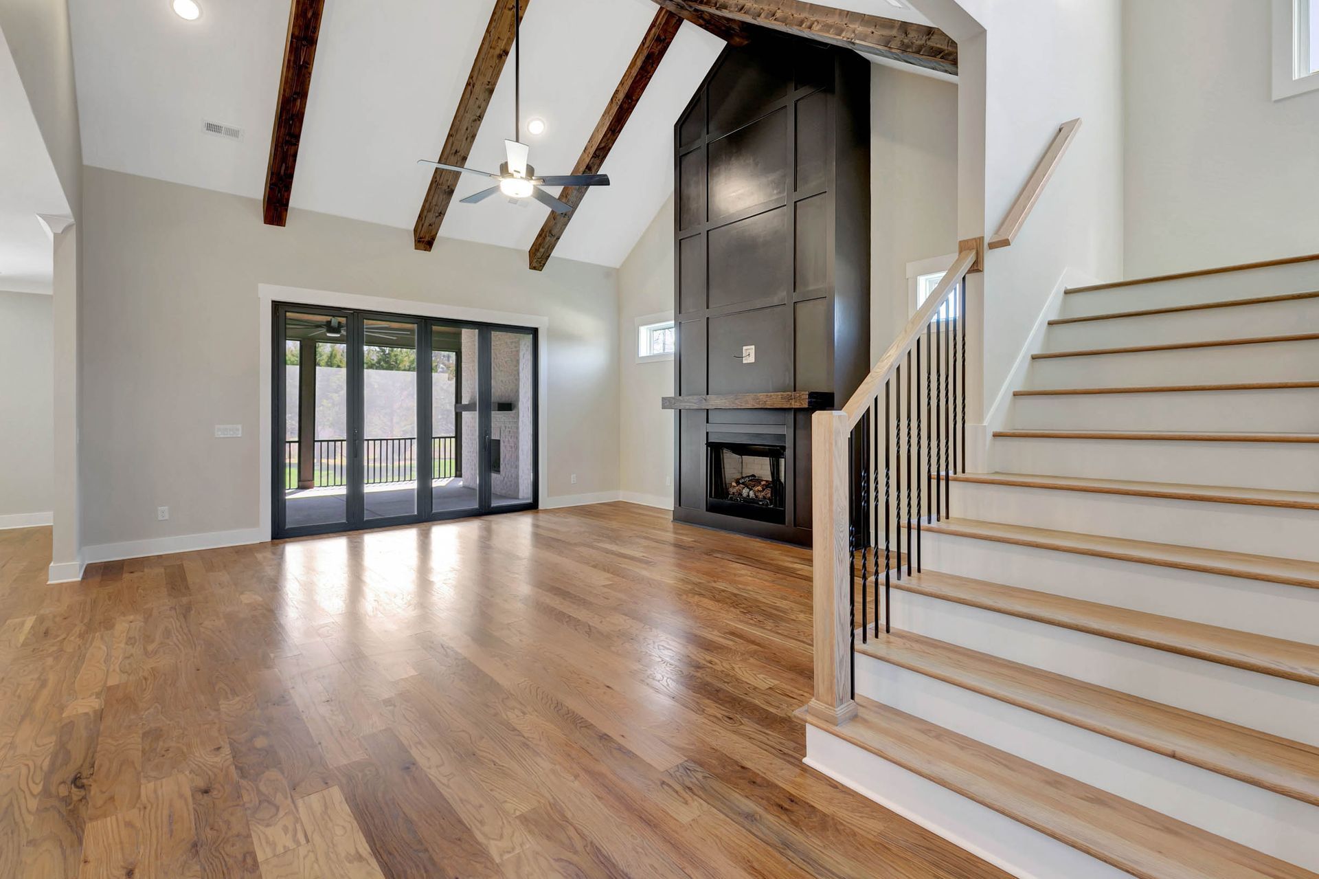 A living room with hardwood floors and stairs leading up to it.