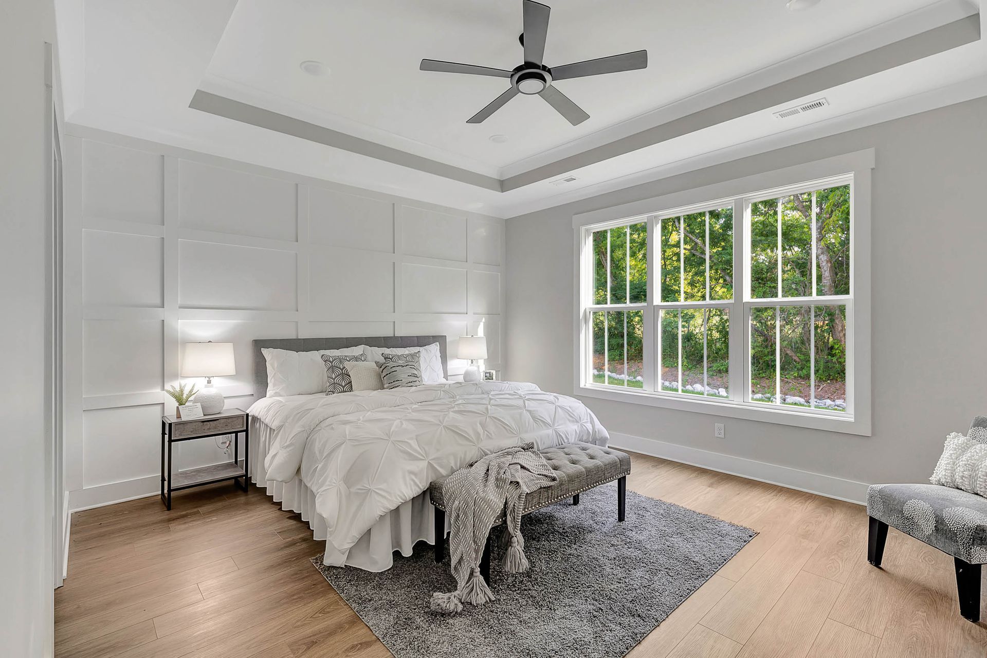 A bedroom with a large bed and a ceiling fan.