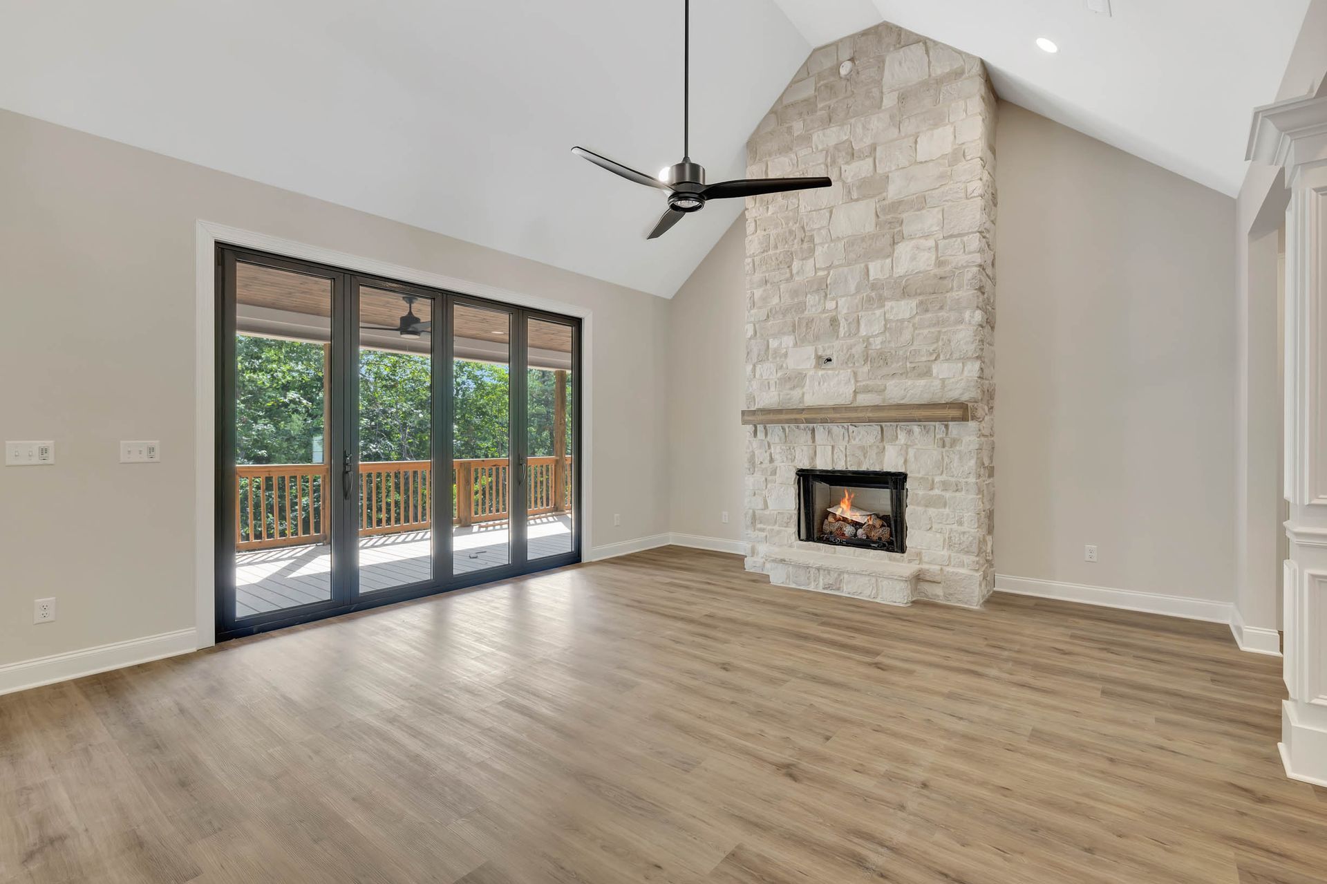 An empty living room with a fireplace and a ceiling fan.