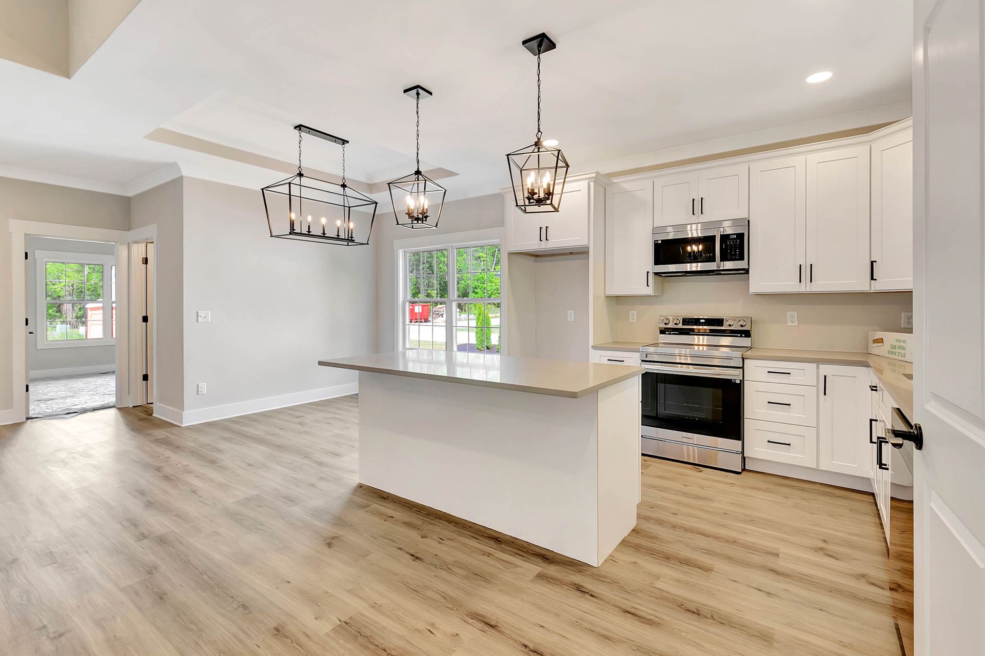 A kitchen with white cabinets , stainless steel appliances , and hardwood floors.