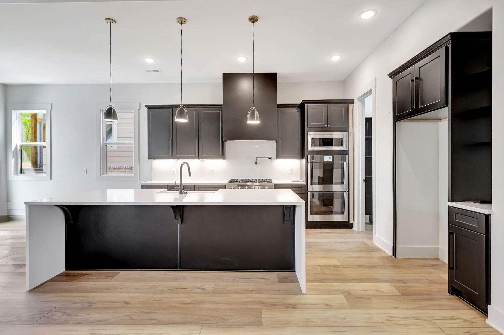 A kitchen with black cabinets and stainless steel appliances