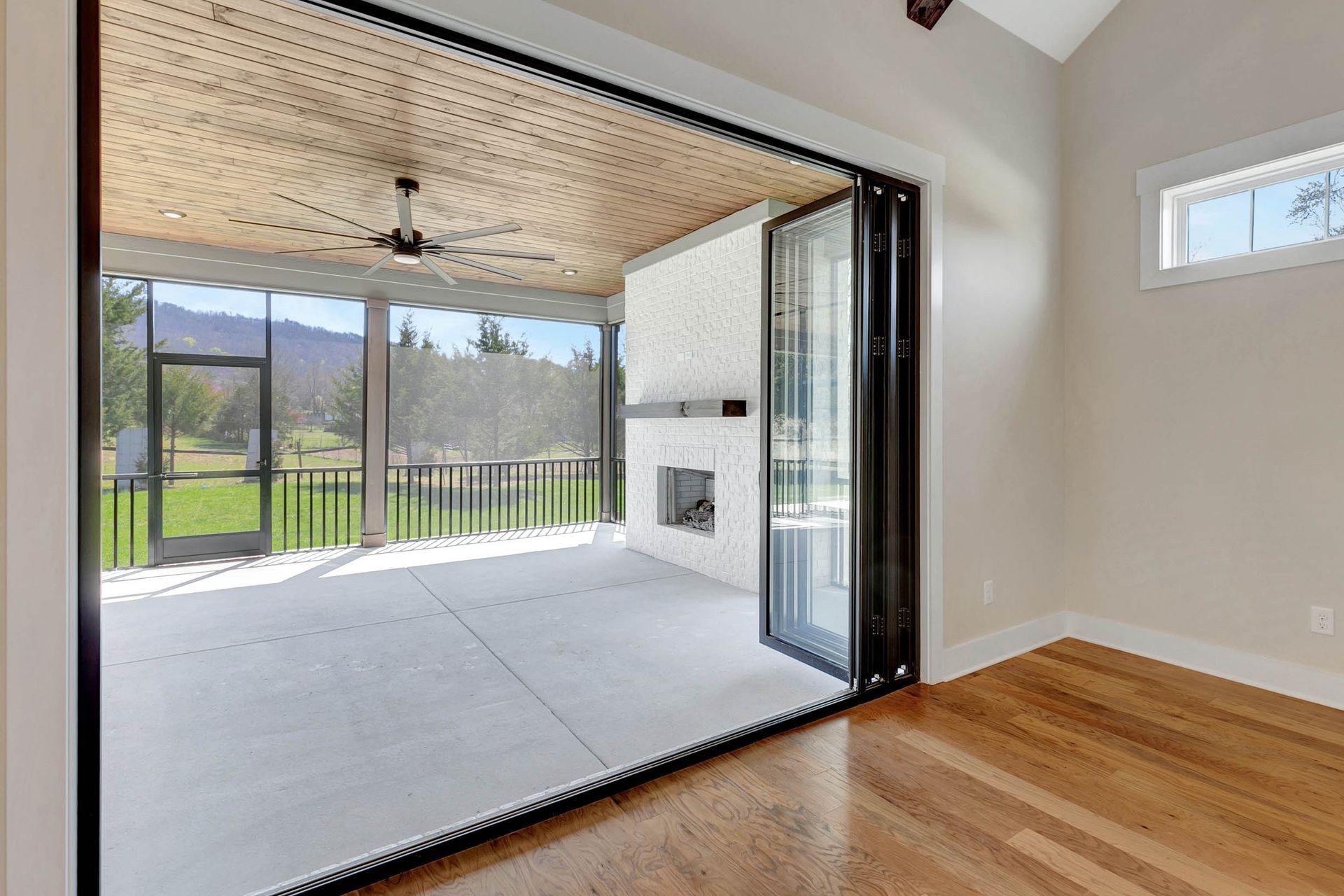 A living room with a screened in porch and a fireplace.