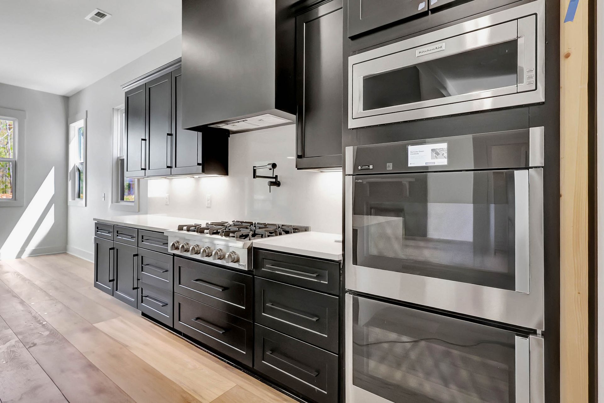 A kitchen with black cabinets and stainless steel appliances.